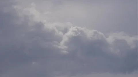 Slow gray clouds drift across an open sky in a time lapse, filling the frame wit Stock Footage 342140189