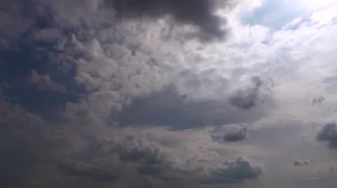 Slow high contrast backlit time lapse clouds against blue sky Stock Footage