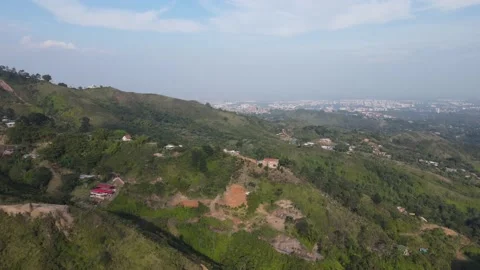 A slow high hangle rotating shot of mountains and hilly areas near the city Vídeo Stock 165176446