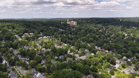 Slow hovering pan above tree-lined Maplewood residential streets and rooftops Stock Footage 344087559
