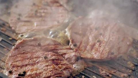 SLOW: Human hand puts a fresh beefsteak on a grill Video stock 70745510