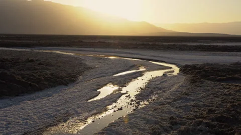 Slow left pan of sunset over a salt flat. Video stock 155444970
