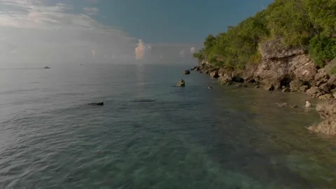 Slow low flight over clear water near a rocky shore. Cinematic view Stock Footage 134946491