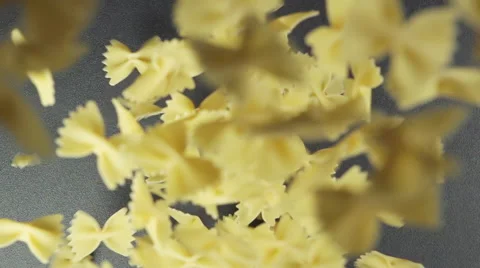 SLOW: Many of bow noodles fall on a black table (top view) Stock Footage 64333591