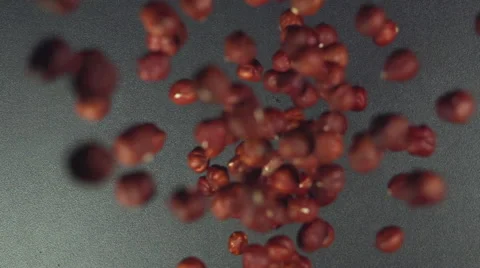 SLOW: Many of hazelnuts fall on a black table (top view) Vídeo Stock 64333488