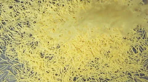 SLOW: Many of small noodles fall on a black table (top view) Vídeo Stock 64333590