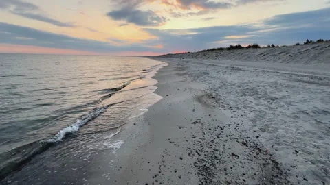 Slow-miton shot of sunset at Graal-Mritz beach: calm waves and colorful sky. Stock Footage 312699752