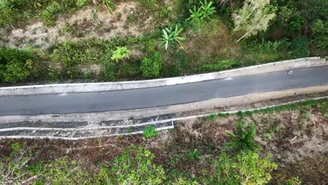 Slow mo aerial top down drone view of woman jogging on rural asphalt road. Stock Footage 342334769