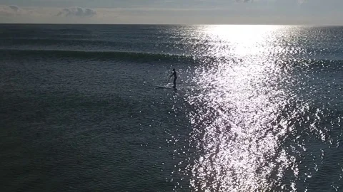 Slow-Mo Aerials of Paddle Surfer charging into the Sun Stock Footage