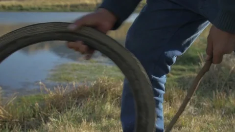 Slow-Mo Andean Child Playing Aros by a Lake Stock Footage 71477749