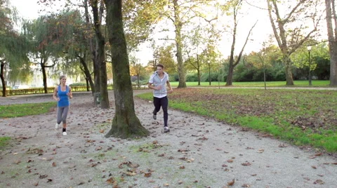 Slow-Mo: Athletic Young Couple Trades Places While Jogging Stock Footage 42161808