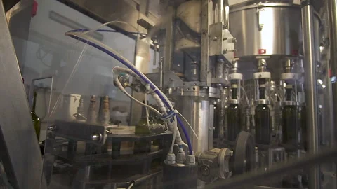 Slow mo. An automatic conveyor puts corks on wine bottles. Stock Footage 155425552