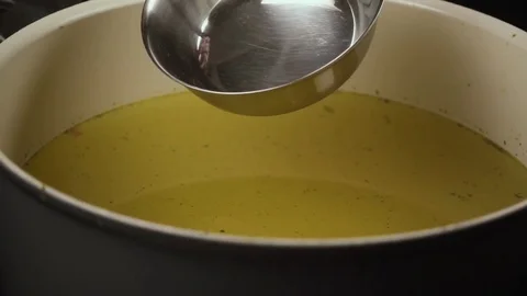 Slow mo. The broth is scooped out with a ladle from the pan Stock Footage 75229801