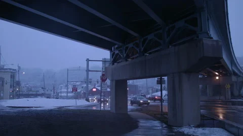 Slow-mo cars drive under snowy overpass Stock Footage