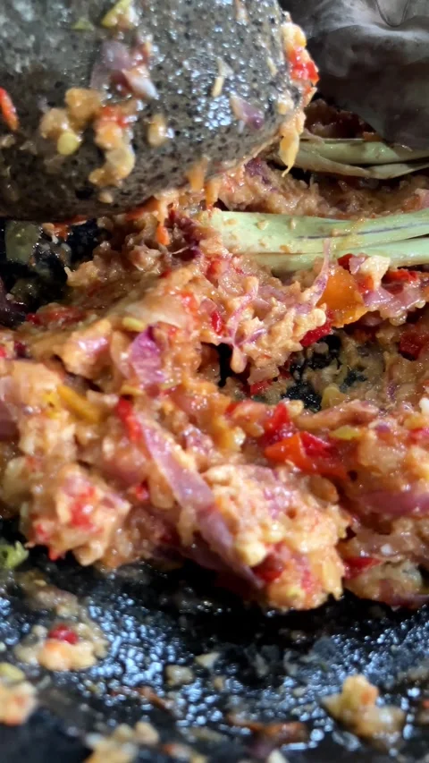 Slow mo close up grinding fresh chili and shallot spices with traditional stone  Video stock 342516310