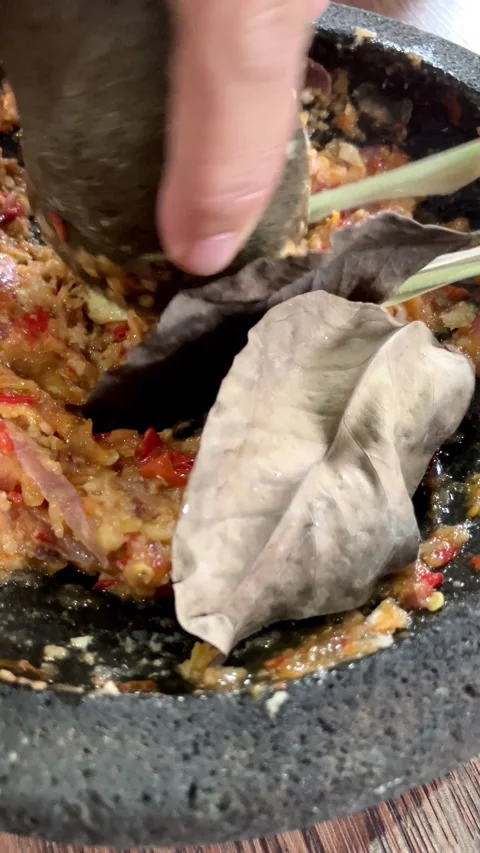 Slow mo close up grinding fresh chili and shallot spices with traditional stone  Stock Footage 342516317