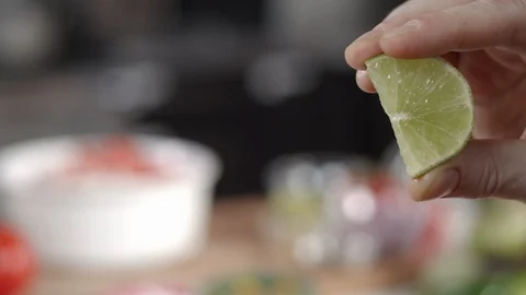 Slow-mo close-up shot of hand squeezing juice out of lime slice Stock Footage 92146950