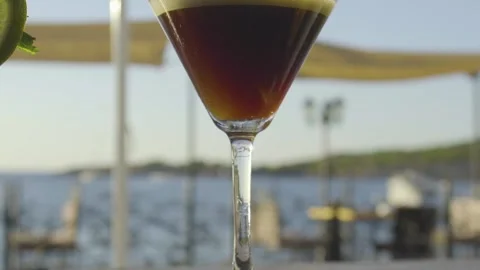 Slow mo of cocktail on a bar with sun setting in the background Stock Footage 140051458
