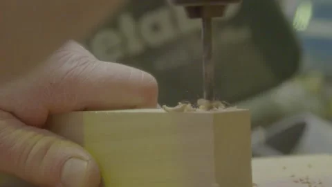 Slow Mo drill into wood block, arm in view Stock Footage 163413627