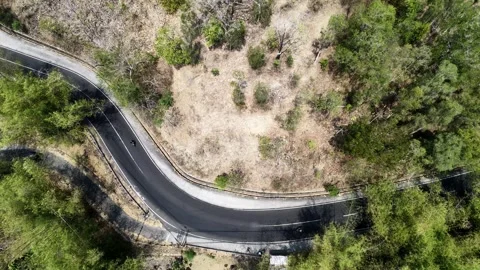 Slow mo drone tracking curvy countryside path in remote hills. 스톡 동영상 344990521