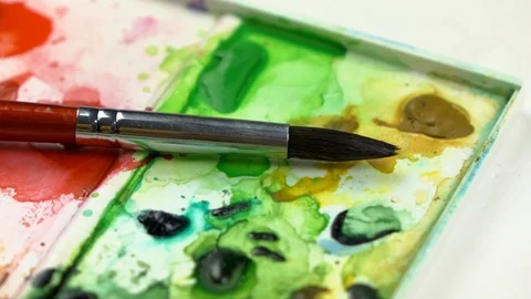 Slow-mo footage. Close-up brush laying on watercolor palete. Dolly shot Видео 87143717