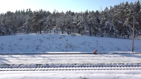 Slow-mo footage. Worker cleans snow on rail station Stock Footage 85367792
