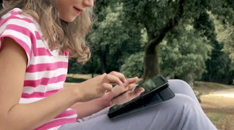 Slow-Mo: Girl Leaning On Tree Playing With Touch Pad Stock Footage 35297396