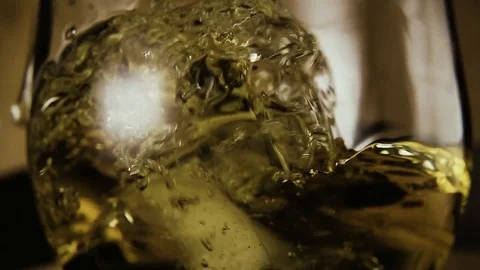 Slow mo. In a glass of brandy drops ice Stock Footage 75412302