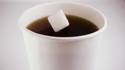 Slow mo. In a glass of tea drops a cube of sugar Stock Footage 75675641