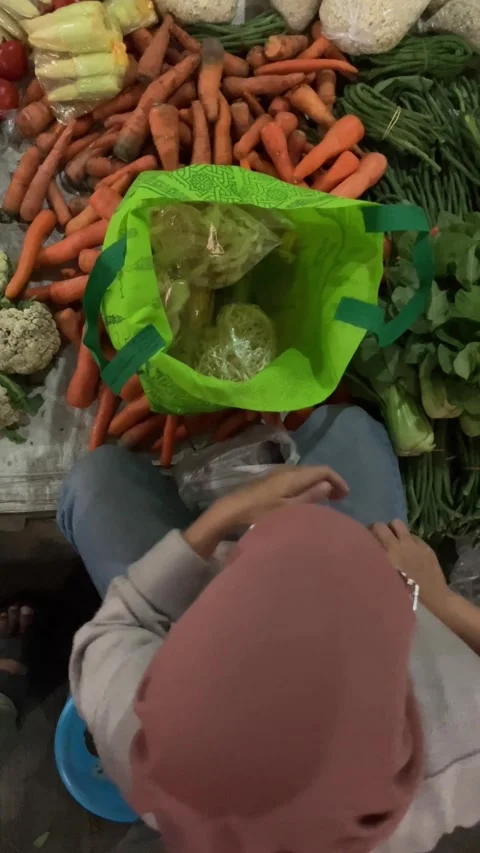 Slow mo high angle woman using money paying for vegetables at local market. Видео 342578928