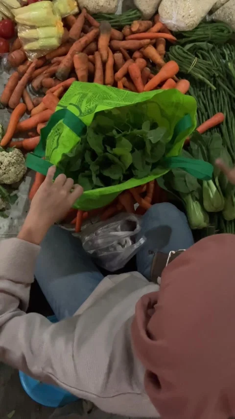 Slow mo high angle woman receiving change buying vegetables at local market. Video stock 342578934