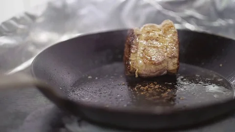 SLOW MO Juicy appetizing meat steak is fried in a frying pan. Drops of boiling Stock Footage 74718992