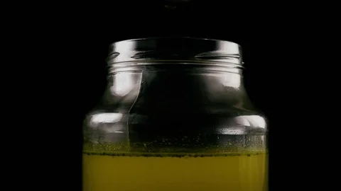 Slow mo. A large stream and a drop of broth in a jar Stock Footage 75230159