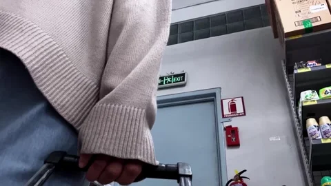 Slow mo low view muslim woman in sweater pushing cart in supermarket aisle. Stock Footage 345436180
