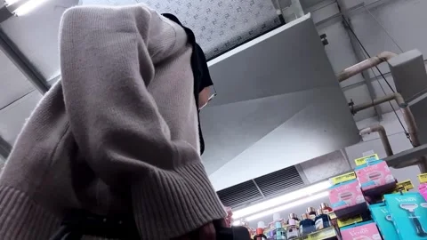Slow mo low view muslim woman in hijab trying perfume in supermarket aisle. Stock Footage 345437666