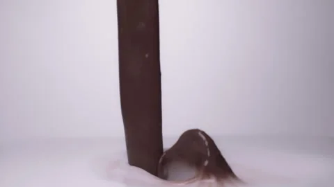 Slow mo, macro shot: Melted chocolate pouring into milk. UHD25p Stock Footage 249587589