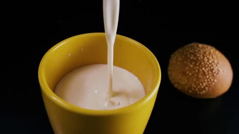 Slow mo. Milk is completely poured into a mug Stock Footage 75268155