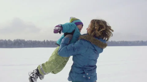 Slow-Mo: Mother Spinning Her Son Outside On Snow Covered Field Stock Footage 33848110