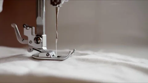 Slow mo needle sewing machine sewing white cotton fabric with a needle. The Stock Footage 134337128