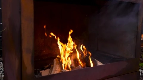Slow-mo Outdoor Camp Fire Burning Round Wooden Logs in Metal Fire Pit Stock Footage 296718496