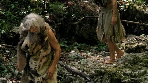Slow Mo Prehistoric Man Observes Other Man Drinking Water Stock Footage 113394382