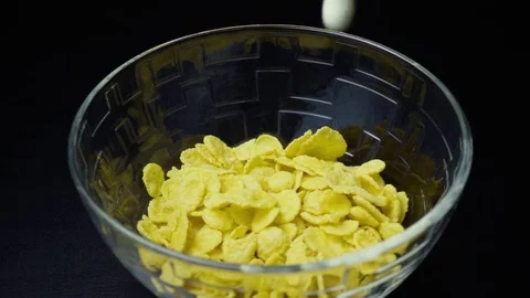 Slow mo prepared breakfast cereals are filled with whole milk in a bowl Video stock 73229608