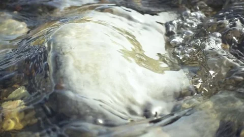 Slow mo pure stream of water is washed by a smooth stone Stock Footage 82425824