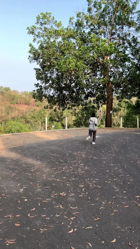 Slow mo rear view of hijab woman jogging away on rural asphalt road. 스톡 동영상 342369388
