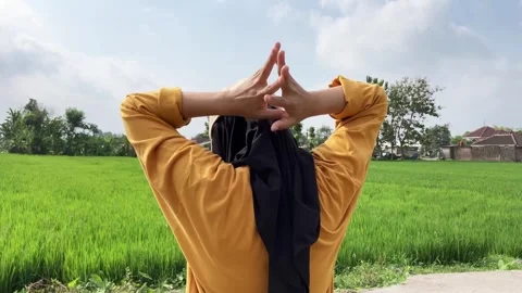Slow mo rear view of hijabi woman doing neck stretch side to side at rice field. Stock Footage 341731782