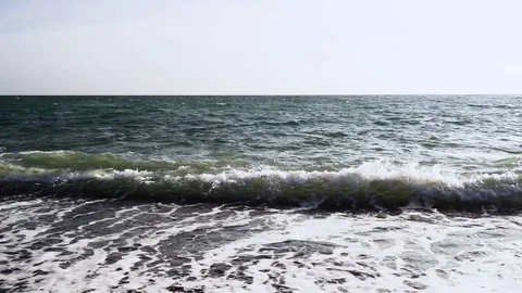 Slow Mo the sea wave rolls up to the pebble beach Stock Footage 82354359
