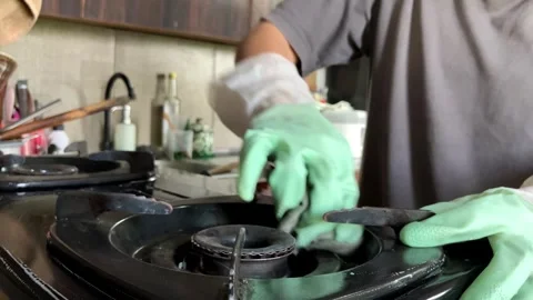 Slow mo selective focus of housewife cleaning gas stove in kitchen. Video stock 345043708