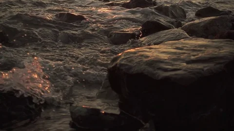 Slow mo sharp stones in water with waves Video stock 81404189