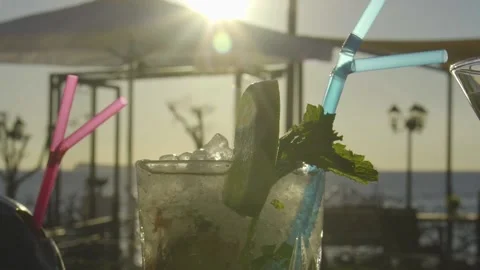 Slow mo shot of cocktail on a bar with sunset in the background Stock Footage 140052845