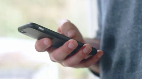 Slow-mo shot of hispanic man scrolling through social media page on smartphone Stock Footage 84479311